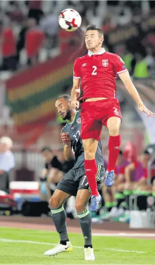  ??  ?? > From left, clockwise, Sam Vokes puts himself about in Belgrade, Jazz Richards is out-jumped by Antonio Rukavina and fans from the Rhondda fly the flag