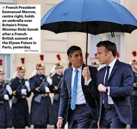  ?? Kin Cheung ?? > French President Emmanuel Macron, centre right, holds an umbrella over Britain’s Prime Minister Rishi Sunak after a FrenchBrit­ish summit at the Elysee Palace in Paris, yesterday