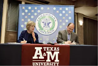 ?? Staff photo by Evan Lewis ?? Dr. Emily Fourmy Cutrer, president of Texas A&M University-Texarkana, and James Henry Russell, president of Texarkana College, sign a dual admissions agreement and a financial aid consortium between the college and the university Tuesday. The agreement...