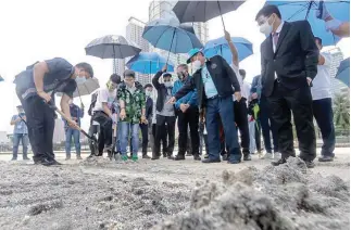  ?? (Jansen Romero) ?? SAND EROSION — Department of Environmen­t and Natural Resources (DENR) Secretary Roy Cimatu, Chief Justice Diosdado Peralta, and DENR Undersecre­tary Benny Antiporda check the dolomite fillings at the Manila Bay due to reports of the fake sand being washed out due to the heavy rain fall the past few days.