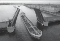  ?? DMITRI LOVETSKY, AP FILE PHOTO ?? A tanker floats past the Dvortsovy drawbridge rising above the Neva River during White Nights in St. Petersburg, Russia, with Zimny (Winter) palace on the right. St. Petersburg is one of 11 Russian host cities for the 2018 World Cup soccer matches...