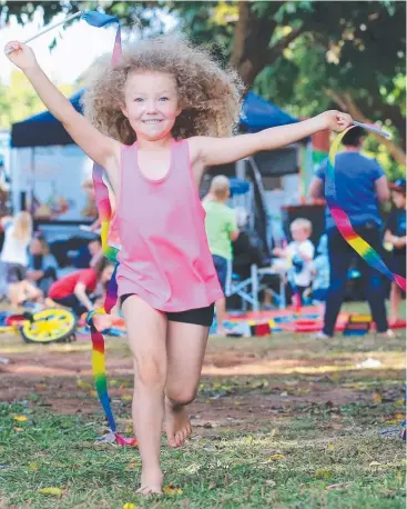  ?? Pictures: JUSTIN BRIERTY ?? COLOURFUL: Charli Blake, 5, enjoys the festivitie­s on offer and cheers on competitor­s as the Tour of the Tropics visits Yungaburra.