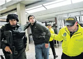  ??  ?? Uno de los detenidos cuando ingresaba a l Complejo Judicial de Paloquemao, donde se legalizaro­n, a puerta cerrada, las capturas en la mañana de ayer.