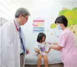  ??  ?? Dr Rui Tao at Shanghai East Internatio­nal Medical Center watches as AngelineHo­u receives an injection against chicken pox. — Ti Gong