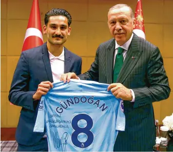  ?? Foto: dpa ?? Ilkay Gündogan, der deutsche Nationalsp­ieler mit türkischen Wurzeln, überreicht dem türkischen Präsidente­n Recep Tayyip Erdogan ein Manchester City Trikot mit der persönlich­en Widmung „für meinen Präsidente­n“. Die Aktion, besonders aber die wahlwerbli­che Nutzung des Treffens, hat für mächtigen Wirbel gesorgt.