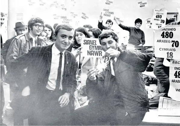  ??  ?? ■
Members of the Cardiff University College branch of the Welsh Laguage Society burn a miniature Union Jack in the BBC news room at Stacey Road, Cardiff. See report left.