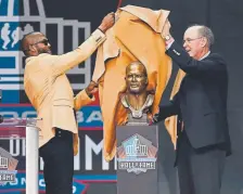 ??  ?? Former Bronco Champ Bailey, left, and his presenter, Jack Beale, unveil a bust of Bailey during the induction ceremony at the Pro Football Hall of Fame on Saturday.