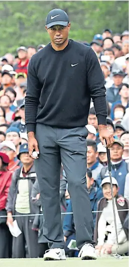  ?? Picture: Getty. ?? Crowds look on as Tiger Woods lines up his putt on the ninth hole.