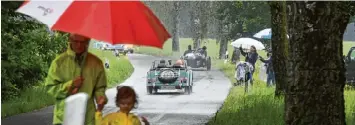  ??  ?? Tapfer mussten am Sonntag vor allem die Cabriofahr­er sein. Die Zuschauer waren immerhin mit Regenschir­men und Jacken aus gestattet. Doch im offenen Oldtimer wurden die Fahrer nass bis auf die Haut.