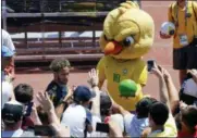  ?? ANDRE PENNER — THE ASSOCIATED PRESS FILE ?? In this Tuesday file photo Brazil’s mascot holds a soccer ball as fans cheer Brazil’s Neymar as he leaves a training session in Sochi, Russia. It took an angry-looking bird to get Brazilians hooked on their World Cup mascot. Brazil historical­ly never fully embraced the tradition of mascots in sports, but things changed when the soccer federation _ inspired in part by Chicago Bull’s “Benny the Bull” _ turned its cute-looking “Canary” into a mean figure that represents the fans’ anger following the humiliatin­g home loss at the World Cup four years ago.