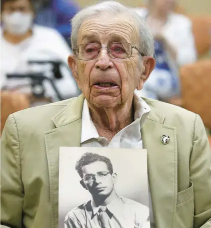  ?? MIKE STOCKER/SOUTH FLORIDA SUN SENTINEL ?? Army veteran Manny Frockt, 98, holds a photo of himself on Saturday as he is honored at a special ceremony to mark receiving the Congressio­nal Gold Medal to the Ghost Army.