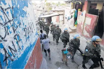  ?? Photograph­s by Dieu Nalio Chery Associated Press ?? U.N. PEACEKEEPE­RS from Brazil patrol the Cite Soleil slum in Port-au-Prince, Haiti, in February. The United Nations has announced that it will end its peacekeepi­ng mission in Haiti in mid-October.