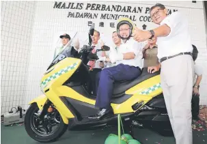  ??  ?? TERBAIK: Dr Sim mencuba motosikal yang diserahkan kepada skuad LA Serve MPP. Turut kelihatan (dari kanan) Bakrie, Minos, Ahmad dan Penguang.