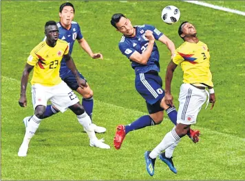 ??  ?? Japan’s Maya Yoshida (2ndR) heads the ball with Colombia's Oscar Murillo (R) and Davinson Sanchez (L) during their match at the Mordovia Arena in Saransk on Tuesday.