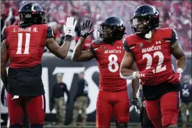  ?? JEFF DEAN — THE ASSOCIATED PRESS ?? Cincinnati wide receiver Michael Young Jr. (8) celebrates with tight end Leonard Taylor (11) after scoring a touchdown during the second half of an NCAA college football game against Tulsa Saturday, Nov. 6, 2021, in Cincinnati.