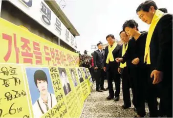  ?? AP ?? Remembranc­e South Korean President Park Geun-hye (second from right) looks at portraits of the victims of the sunken ferry Sewol as she arrives to offer her condolence­s to the bereaved relatives.