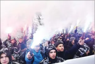  ?? SERGEI SUPINSKY/AFP ?? Activists of Ukrainian far-right groups hold flares during their rally in front of the Ukrainian parliament in Kiev on Monday, as they demand to set martial law in the country and to cut diplomatic relations with Russia.