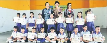  ??  ?? Tadika Kami children pose with their graduation certificat­es with Kong (left) and their teachers.