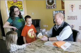  ?? Lake Fong/Post-Gazette ?? Adam Rubritz, 7, of Scott presents his home-made holey bread to chef Mario Batali at an autograph session for his latest cookbook Saturday at the Settler’s Ridge Market District store in Robinson. At left is Adam's mother, Julie, and sister, Charlotte, 4.