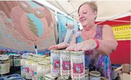  ?? JOHN MCCALL/SUN SENTINEL ?? Pat “The Garlic Lady” West restocks her display of pickled garlic at the South Florida Garlic Fest in Lake Worth on Feb. 10, 2019.