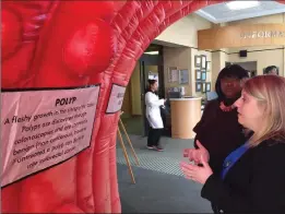  ?? Photo by Jonathan Bissonnett­e ?? Kent Hospital assistant chief of surgery Melissa Murphy points out the polyps inside the Strollin’ Colon to Angela Hall-Jones of the American Cancer Society.