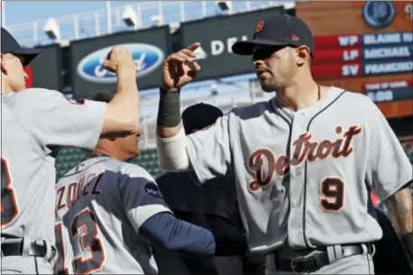  ?? JIM MONE — THE ASSOCIATED PRESS ?? Detroit Tigers’ Nicholas Castellano­s, right, goes through Twins in a baseball game Saturday in Minneapoli­s. the celebratio­n line after the Tigers defeated the Minnesota