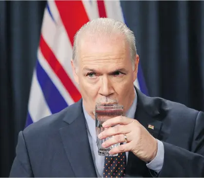  ?? CHAD HIPOLITO/THE CANADIAN PRESS ?? Premier John Horgan pauses to refresh himself at a news conference in Victoria on Tuesday following the announceme­nt of the federal government’s plan to buy the Trans Mountain Pipeline from Kinder Morgan.