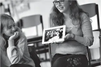  ?? Associated Press ?? ■ In this June 25 photo, Jewish teenager Sophie Steiert, right, shows a picture of Jewish daily life on a tablet computer as Laura Schulmann looks on during a lesson as part of a project of religions at the Bohnstedt Gymnasium high school in Luckau,...