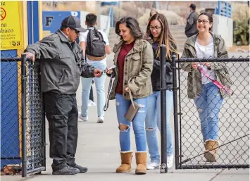  ?? GABRIELA CAMPOS/NEW MEXICAN FILE PHOTO ?? Security guard Elton Montoya checks students’ ID cards before entering or exiting the school’s campus following a news conference on school safety at Santa Fe High in February.