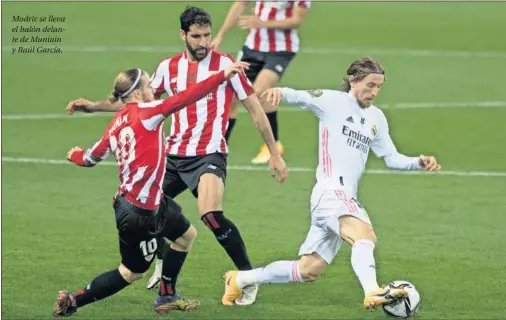  ??  ?? Modric se lleva el balón delante de Muniain y Raúl García.