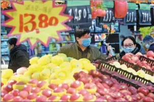  ?? LONG WEI / FOR CHINA DAILY ?? Shoppers buy fruit at a supermarke­t in Hangzhou, Zhejiang province.