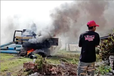  ?? HENG CHIVOAN ?? An excavator and water pipes burn next to a crematoriu­m after being set ablaze in Khtor village in Phnom Penh’s Russey Keo district on November 23, 2013.