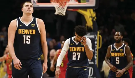  ?? Aaron Ontiveroz, Denver Post file ?? Nikola Jokic, left, of the Nuggets walks off the court with Jamal Murray, center, and Will Barton in November. Denver is still waiting for players to arrive in Orlando.