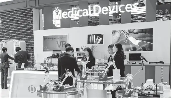  ?? LYU LIANG / FOR CHINA DAILY ?? Visitors check out exhibits at the booth of Johnson & Johnson during the second China Internatio­nal Import Expo in Shanghai on Nov 7, 2019.