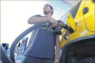  ?? AP FILE PHOTO ?? Cristian Rodriguez puts fuel in his vehicle in Sacramento, Calif., in late October.