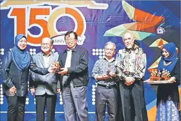  ??  ?? Abang Johari (third left) presents the prize to one of the winners of the games and competitio­ns run by BNBBC Sarawak as part of the activities during the dinner. On the chief minister’s right is Uggah, while looking on from right are Asfia and Paulus.