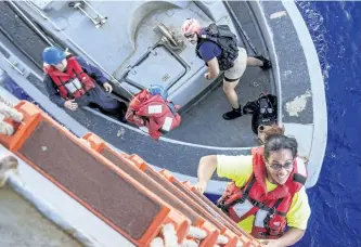  ?? THE ASSOCIATED PRESS ?? Tasha Fuiava, an American mariner who had been sailing for five months on a damaged sailboat, climbs a ladder to board the USS Ashland after the navy ship rescued Fuiava, Jennifer Appel and their dogs after being lost at sea for several months while...