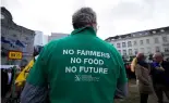  ?? ?? Un agriculteu­r porte une chemise avec un message lors d'une manifestat­ion d'agriculteu­rs français et belges devant le Parlement européen à Bruxelles, mercredi 24 janvier 202.