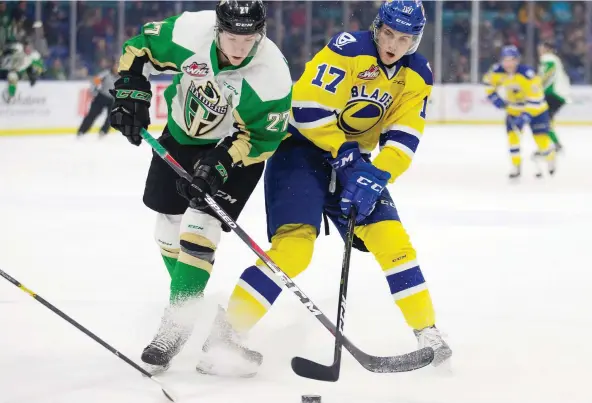  ?? KaYLE NEIS ?? -Prince Albert Raiders forward Parker Kelly fights for the puck against Blades forward Eric Florchuk during Friday’s game at SaskTel Centre.