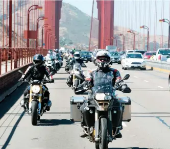  ?? CHRISTINA SHOOK/AP ?? Clickenger leads a group of women riders over the Golden Gate Bridge in San Francisco at the end of a crosscount­ry trip to honour two sisters from Brooklyn, N.Y., who made a similar ride in 1916. Clickenger operates Women’s Motorcycle Tours, which...