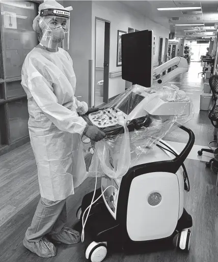  ?? COURTESY OF AURORA ST. LUKE'S MEDICAL CENTER. PHOTOS ?? Aurora St. Luke's sonographe­r Abby Payne stands with the cardiac ultrasound machine used by the hospital in a technique that has cut the time for heart scans of COVID-19 patients almost in half, to about 35 minutes.