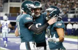 ?? MICHAEL AINSWORTH — THE ASSOCIATED PRESS ?? Eagles Carson Wentz, let, Zach Ertz (86) and Trey Burton, right, celebrate a two-point conversion caught by Burton in the second half against the Cowboys on Sunday in Arlington, Texas.