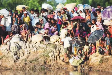  ?? AFP ?? Rohingya refugees wait after crossing the Naf river from Myanmar into Bangladesh, to be taken to refugee camps. Bangladesh said that a working group would be set up within three weeks to agree on the arrangemen­ts for the repatriati­on.
