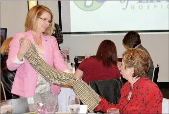  ?? Janelle Jessen/Siloam Sunday ?? Auxiliary member Audra Farrell showed the pajamas that auxiliary members made for patients so they could have something more comfortabl­e to wear than hospital gowns.