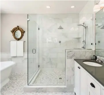  ??  ?? Those contemplat­ing their own bathroom renovation­s may consider multiple showerhead­s and heated flooring for a spalike retreat.