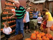  ?? Olivia Vardy / Rome News-Tribune ?? Trinity United Methodist Church members of all ages gather together to celebrate fall by unloading and organizing the second shipment of pumpkins Sunday afternoon.