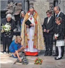  ?? FOTO: DPA ?? Lucy Hawking legt Blumen an der Urne ihres Vaters nieder. Die Asche des Starphysik­ers wurde in der Westminste­r Abbey zwischen Isaac Newton und Charles Darwin beigesetzt.
