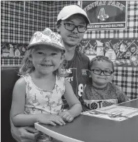  ??  ?? John Michael Currie and two of his children Amelia and Nathan Poirier, sit in a booth at the newly reopened Me and the Mrs. restaurant and convenienc­e store in St. Andrews Channel.
