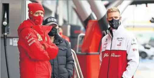  ??  ?? Sebastian Vettel (izquierda) charla con Mick Schumacher (derecha) mientras esperan a que se puedan disputar los libres en Nurburgrin­g.