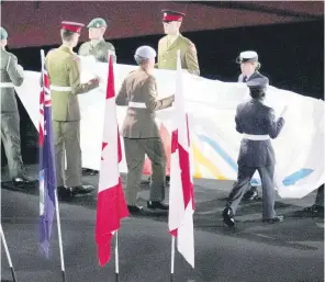  ?? AP PHOTO ?? Members of England’s military lower the Commonweal­th flag during the Commonweal­th Games’ closing ceremony at the Alexander stadium in Birmingham, England on Monday.